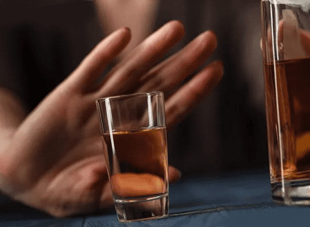 Стакан с водкой и рука